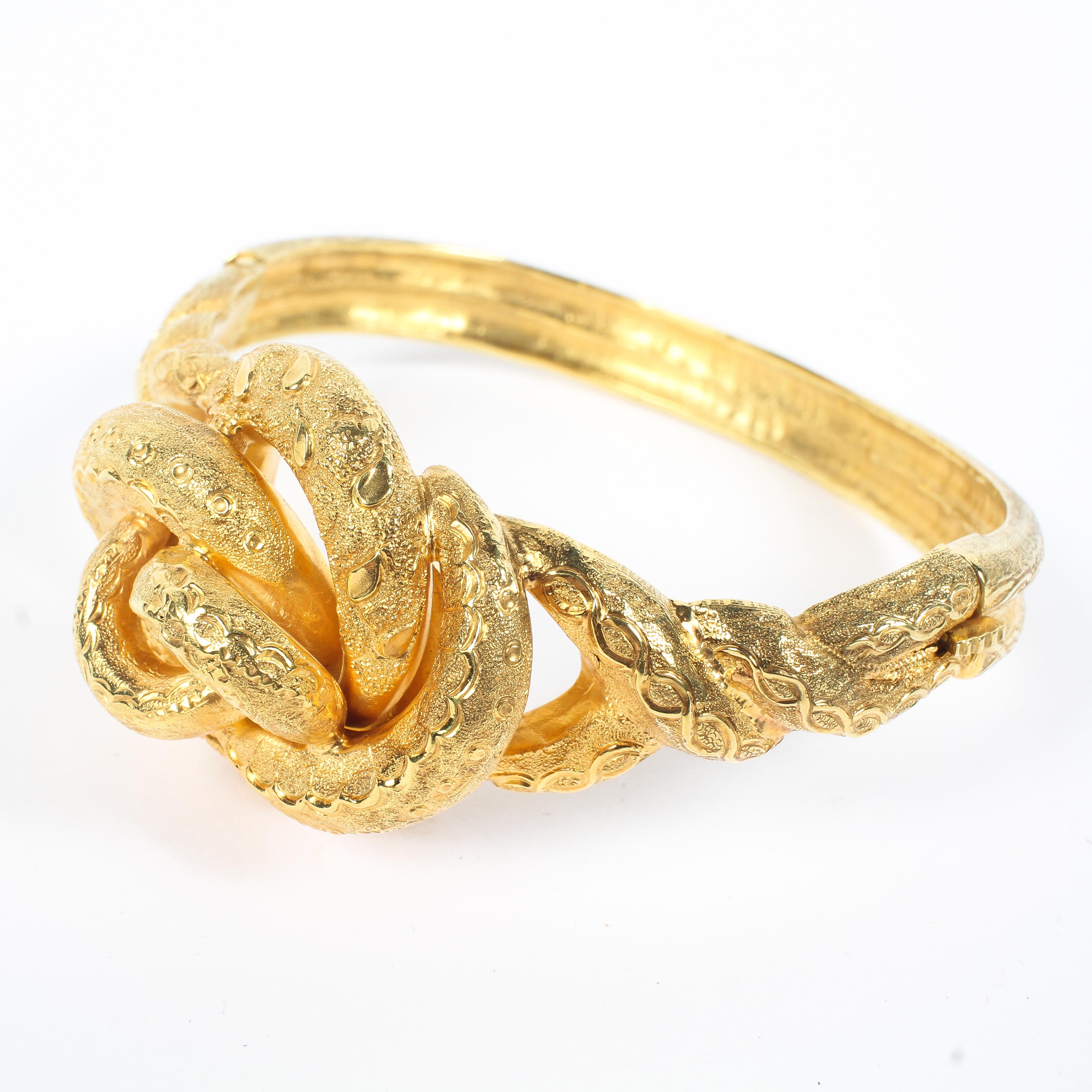 An unmarked yellow metal knot bangle bracelet. 31.3g. Internal 6cm.