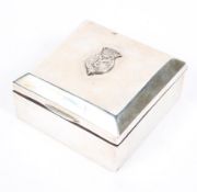 A sterling silver cedar lined square cigarette box with applied white metal armorial to lid,