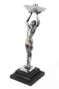 An Art Deco chromed metal figural table lamp, cast as a female nude,