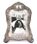 A sterling silver mounted desk top photograph frame with embossed decoration and velvet lined back.