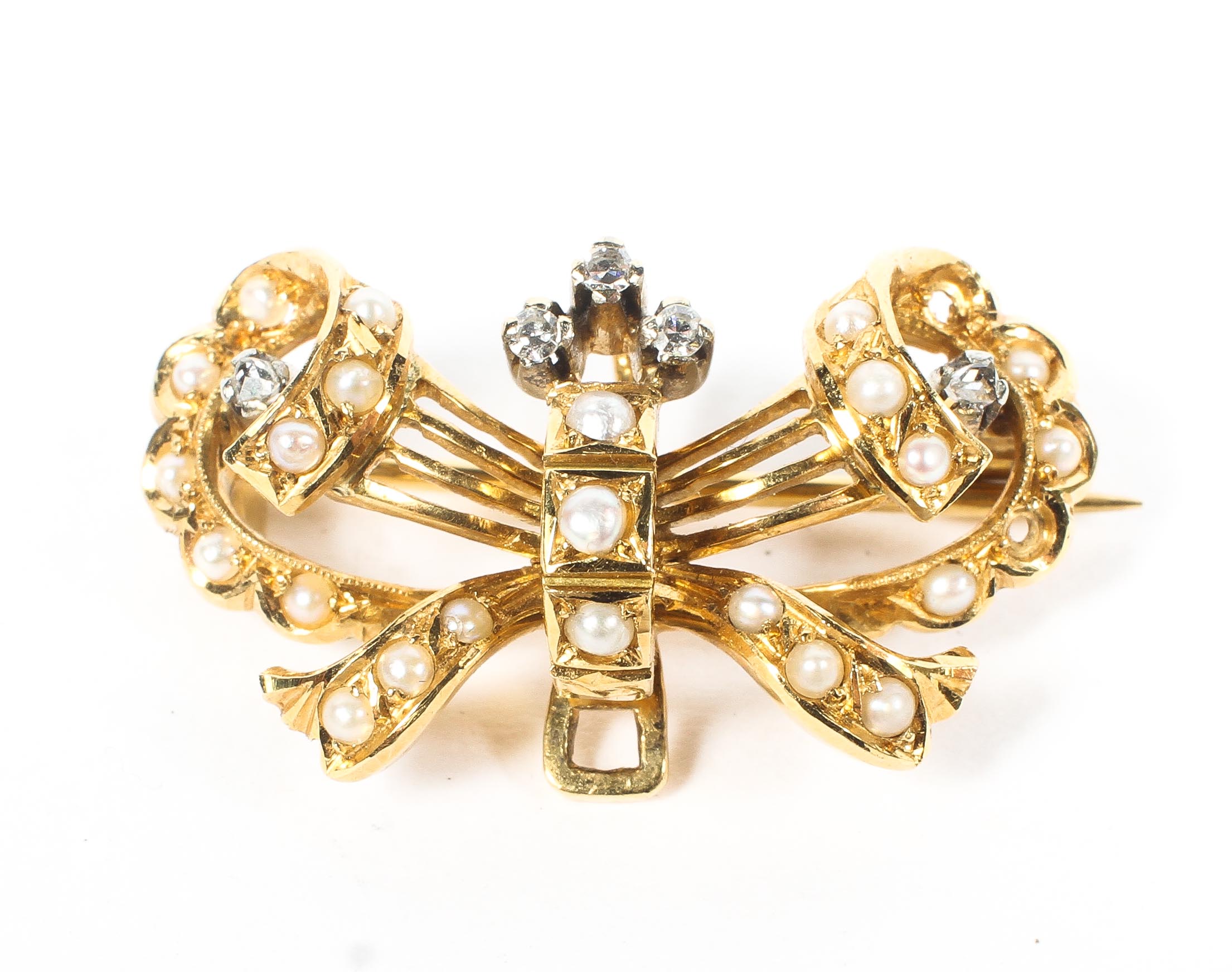 A yellow metal diamond and seed pearl bow brooch. 6.5g.