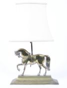 A brass lamp base cast as a horse on waisted plinth base, fitted for electricty, with cream shade,