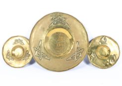 Three brass Arts and Crafts style dishes, early 20th century, two small and one large,