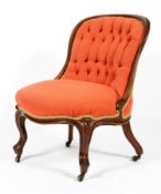 A Victorian button back nursing chair, upholstered in red/orange fabric,
