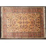 An Oriental style wool rug, pink ground with central large geometric panel to centre, 280cm x 182cm.