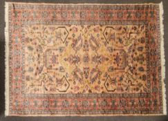 An Oriental style wool rug, pink ground with central large geometric panel to centre, 280cm x 182cm.