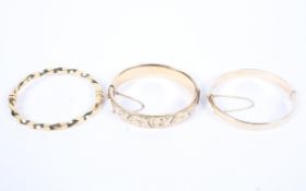 Two 9ct gold metal core bangles together with an unmarked yellow metal bangle.