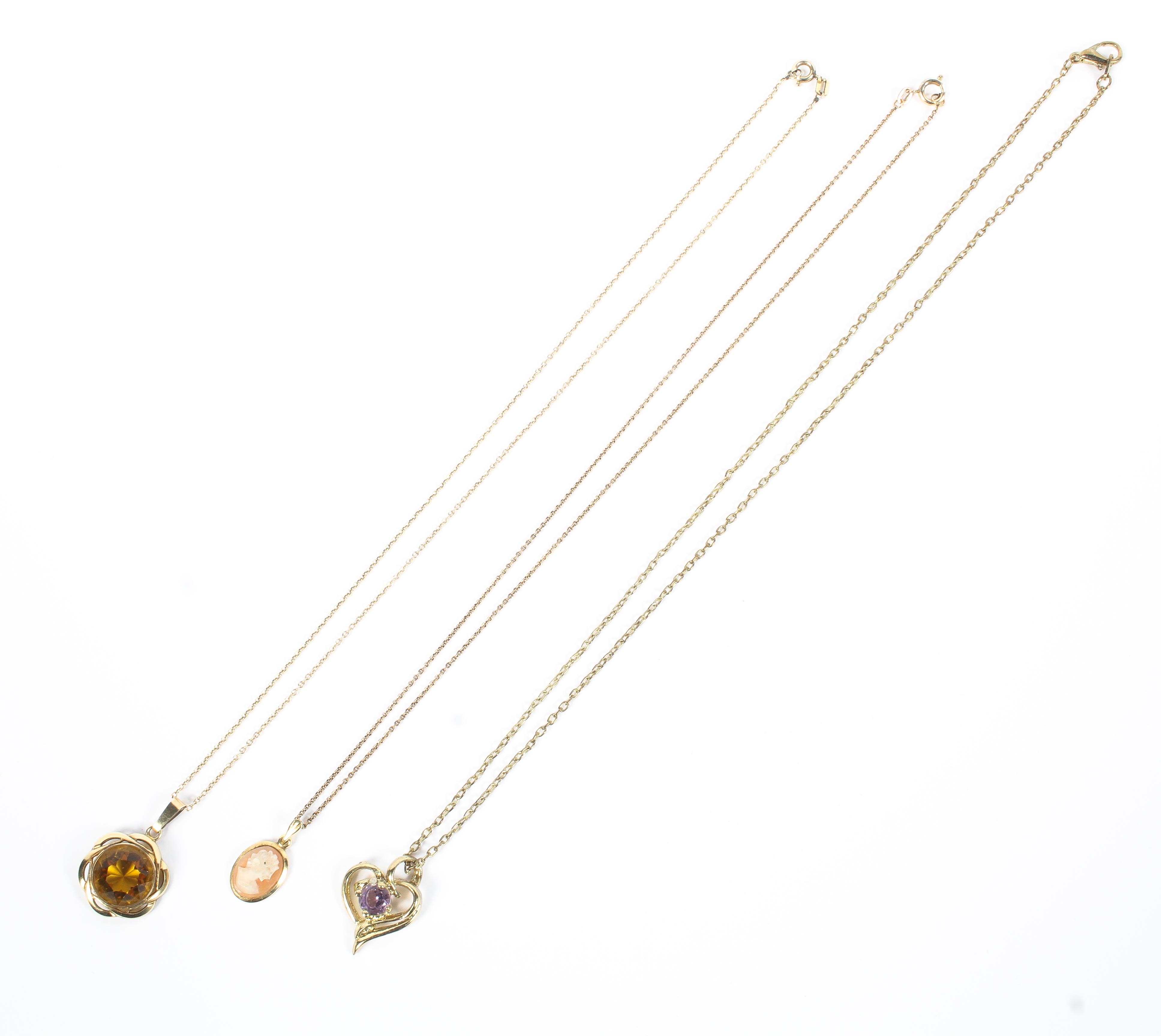 Three unmarked yellow metal gem set pendants on yellow metal chains. 10.7g.
