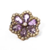 A 19th century unmarked yellow metal amethyst and seed pearl flower brooch. 6.7g. 28mm(d).