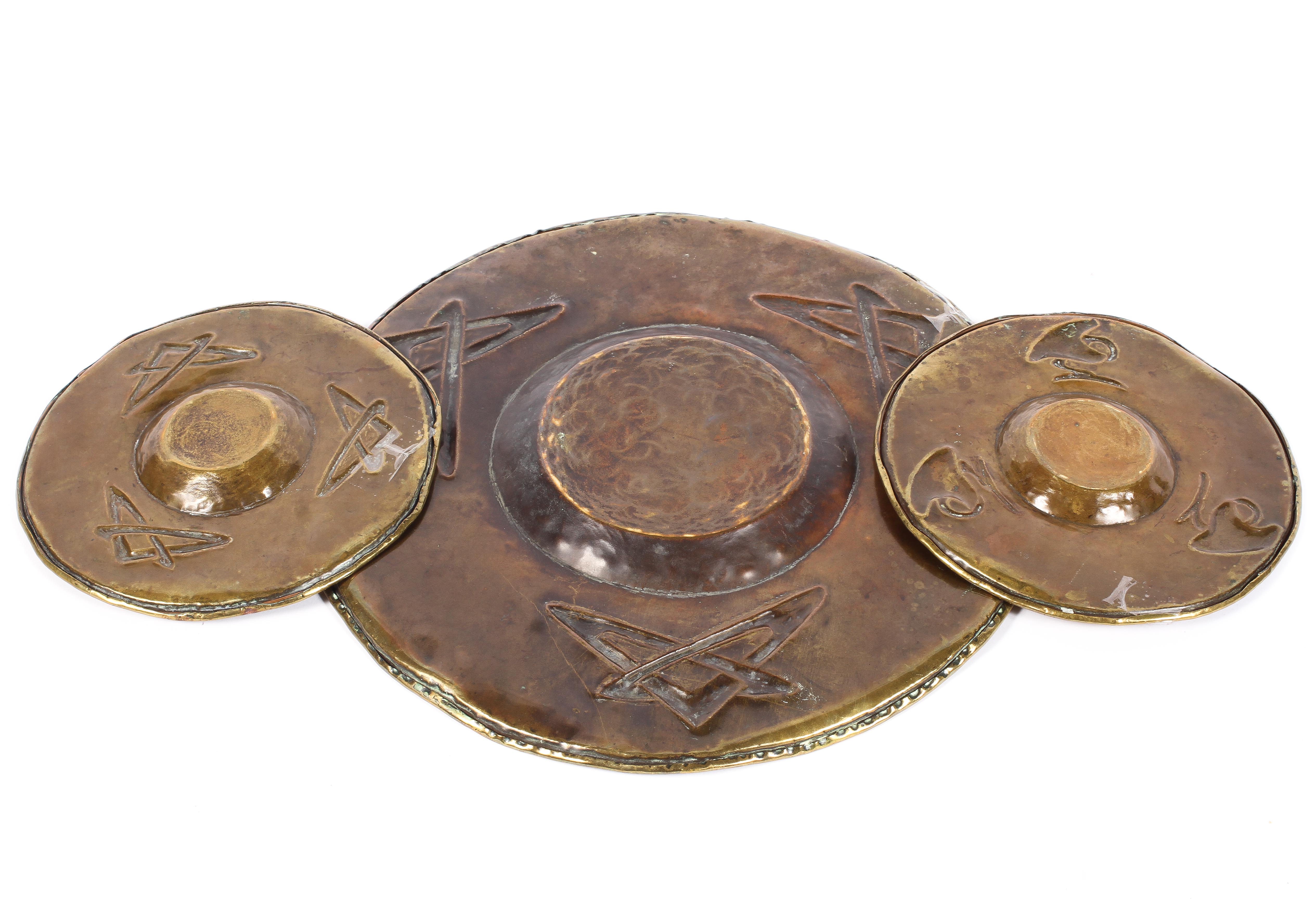 Three brass Arts and Crafts style dishes, early 20th century, two small and one large, - Image 2 of 2