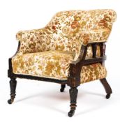 An Edwardian upholstered tub chair in floral fabric on turned front legs and original castors.