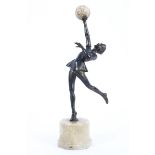 An Art Deco style spelter figure of a dancing girl carrying an onyx ball,