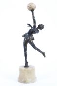 An Art Deco style spelter figure of a dancing girl carrying an onyx ball,