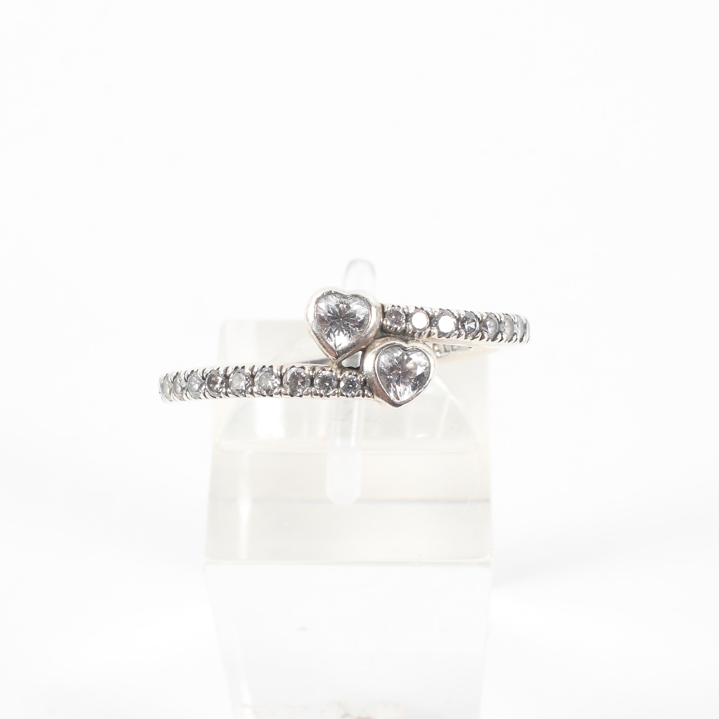 A sterling silver crossover ring set with heart and round cut colourless cubic zirconia. - Image 2 of 4