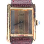 Cartier. A ladies Must de Cartier silver gilt square face wrist watch on brown leather strap.
