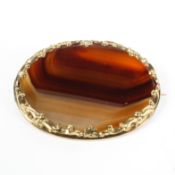 A large yellow metal mounted oval banded agate brooch. 5.5cm x 4cm.