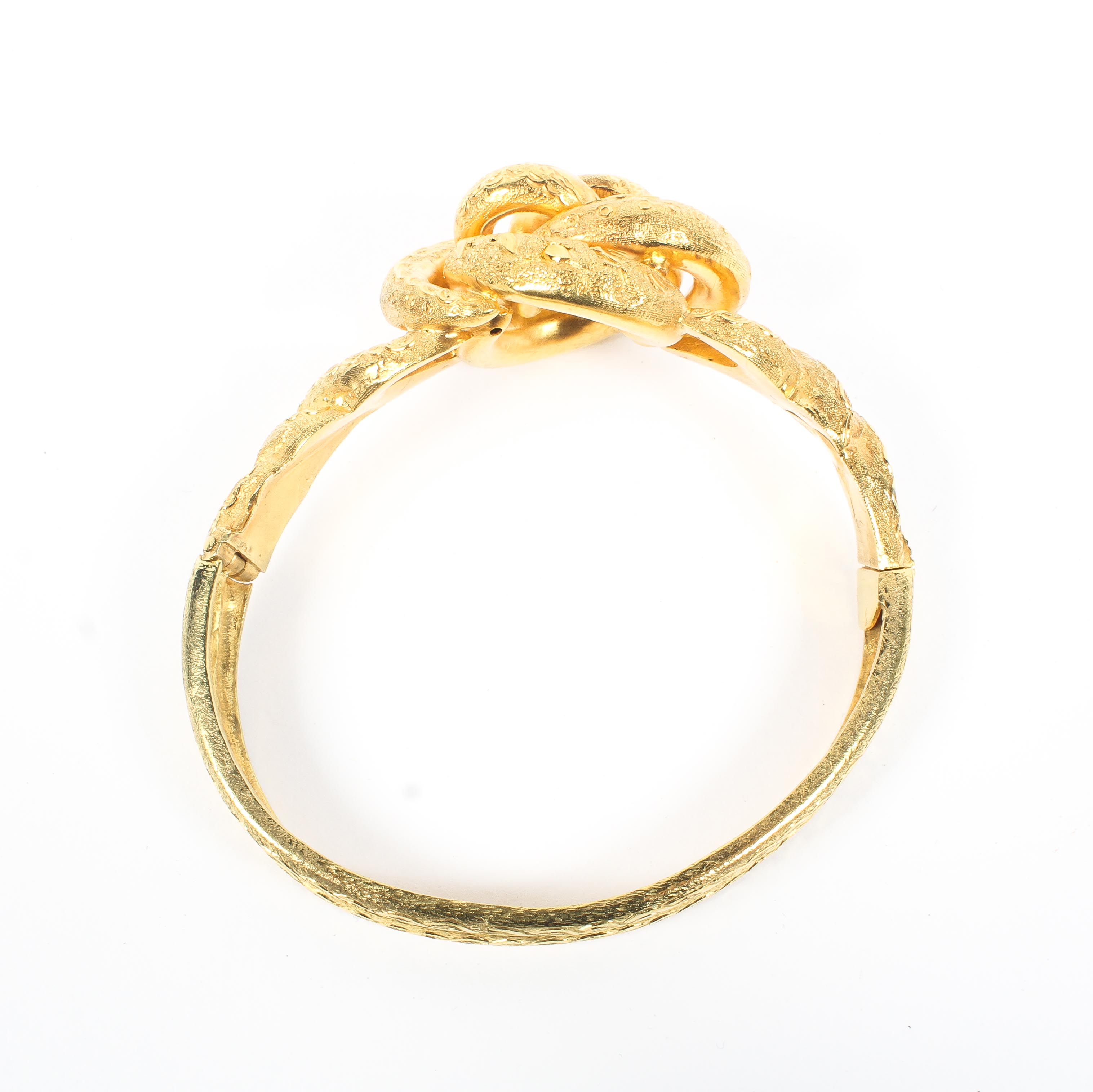 An unmarked yellow metal knot bangle bracelet. 31.3g. Internal 6cm. - Image 2 of 2