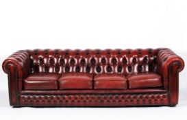 A large 20th Century Chesterfield sofa, with buttoned red leather upholstery, on wheels,