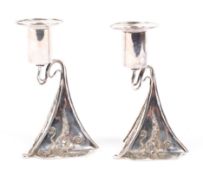 A pair of sterling silver Art Nouveau style candlesticks with applied abstract decoration with