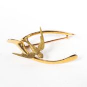 An unmarked yellow metal wishbone and swallow brooch. 5.6g.