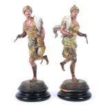 Two arabesque style painted and gilt spelter figures of a hunter and huntress