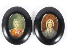 A pair of Victorian portraits of a gentleman and his wife on ivory, he in military uniform,