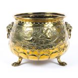 A Dutch brass footed planter, with lion masks, cast with birds amongst branches, on paw feet,