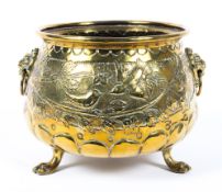A Dutch brass footed planter, with lion masks, cast with birds amongst branches, on paw feet,