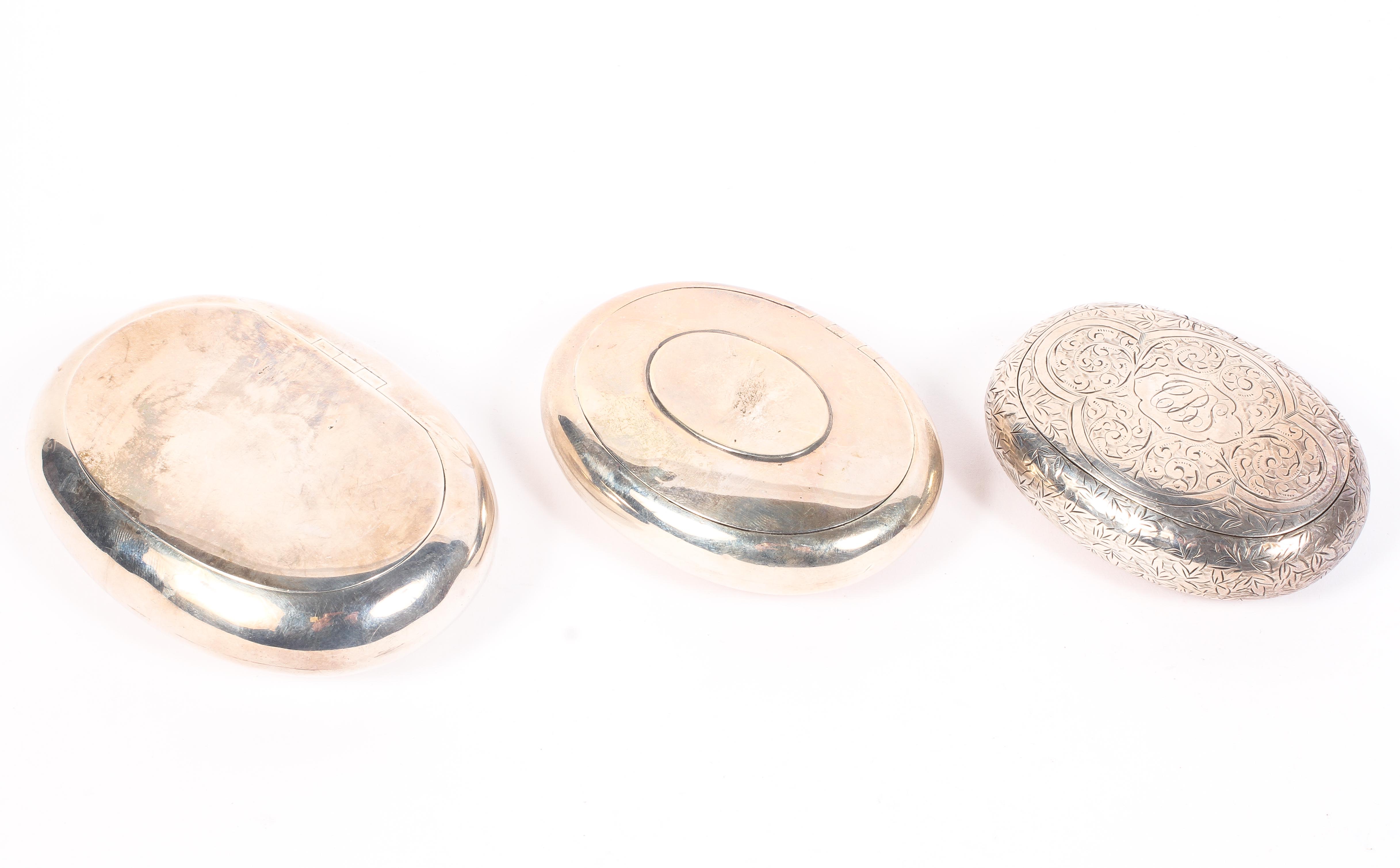 Three silver snuff boxes of oval form, each with squeeze opening mechanism,