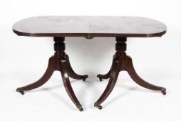 A Regency style mahogany twin pedestal dining table, with reeded d-shaped ends,