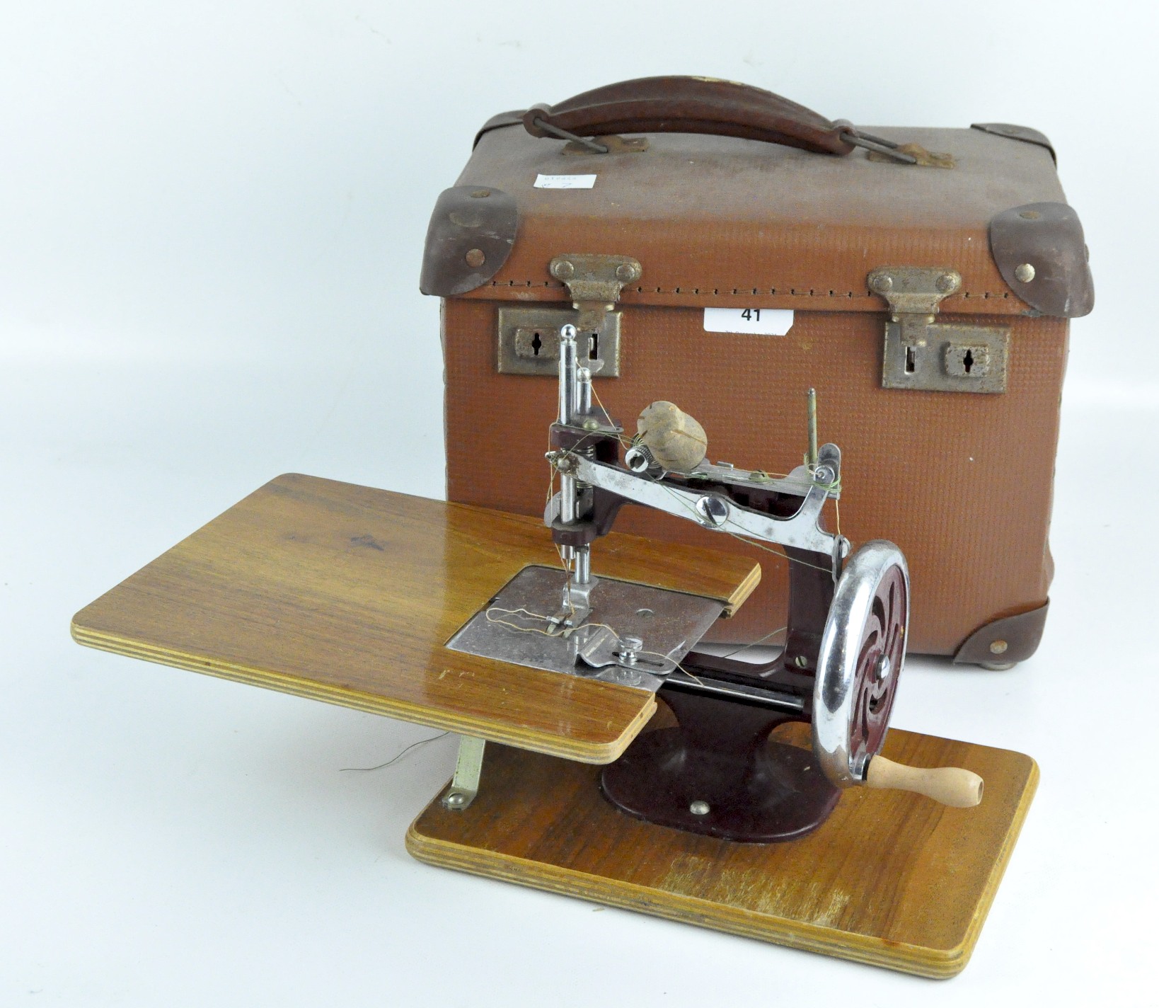 A mid-century red and chrome Essex miniature sewing machine, on a wooden base,