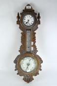 An Edwardian barometer, and a thermometer in carved oak wall hanging case,