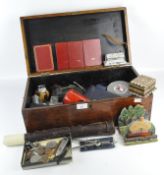 A vintage wooden box with handles containing coins, lighters, cameras and more