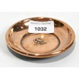 A small circular copper dish, decorated with an anchor, bird and the name 'H.M.S. Hood'
