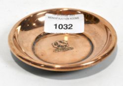 A small circular copper dish, decorated with an anchor, bird and the name 'H.M.S. Hood'