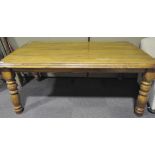 A early 20th century wooden kitchen table, with ribbed top and curved corners,
