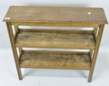 A rustic pine shelving unit, three levels, on square supports,