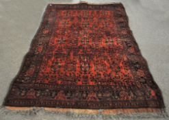 A large 20th century ground carpet, geometric and floral designs on a red ground,