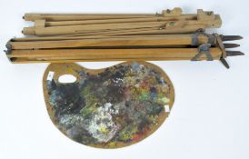 A wooden adjustable easel, together with a tripod and artist's palette
