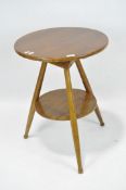 A wooden cricket table, the circular top with a shelf underneath and turned supports, height 65cm.