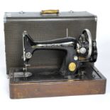 A vintage Singer sewing machine, painted in black with gilt embellishments,