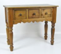 A 20th century pine side table, fitted with three drawers, raised on turned supports,