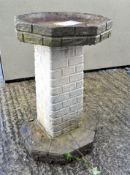 A composite stone bird bath, the pedestal moulded with brickwork,