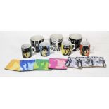 A set of four Beatles mugs, each featuring the face of an individual,