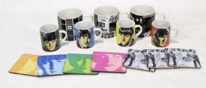A set of four Beatles mugs, each featuring the face of an individual,