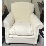 A early 20th century deep seated armchair, with scroll arms, cream upholstery,