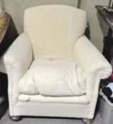 A early 20th century deep seated armchair, with scroll arms, cream upholstery,