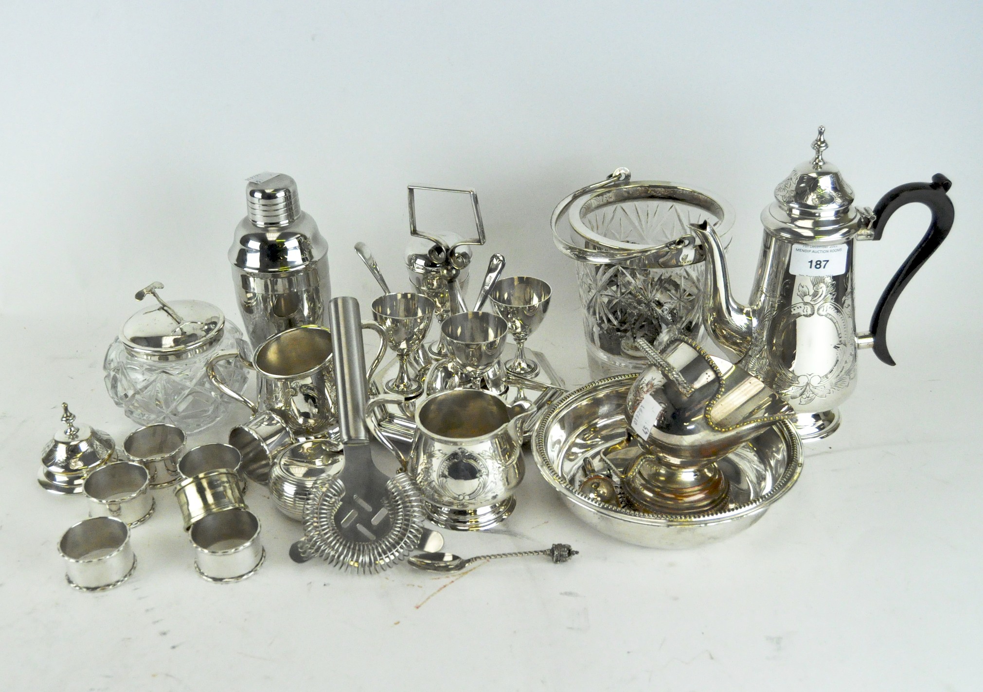 A collection of silver plate, including napkin rings, cocktail shaker,