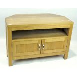 A contemporary television unit, the shaped top with an open shelf and twin handled cupboard beneath,