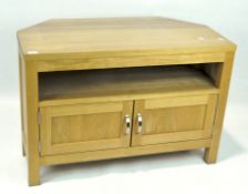 A contemporary television unit, the shaped top with an open shelf and twin handled cupboard beneath,